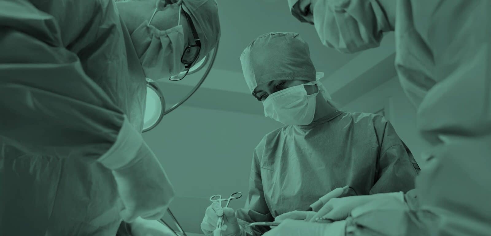 Surgical team in blue medical suits using medical instruments and performing surgery.